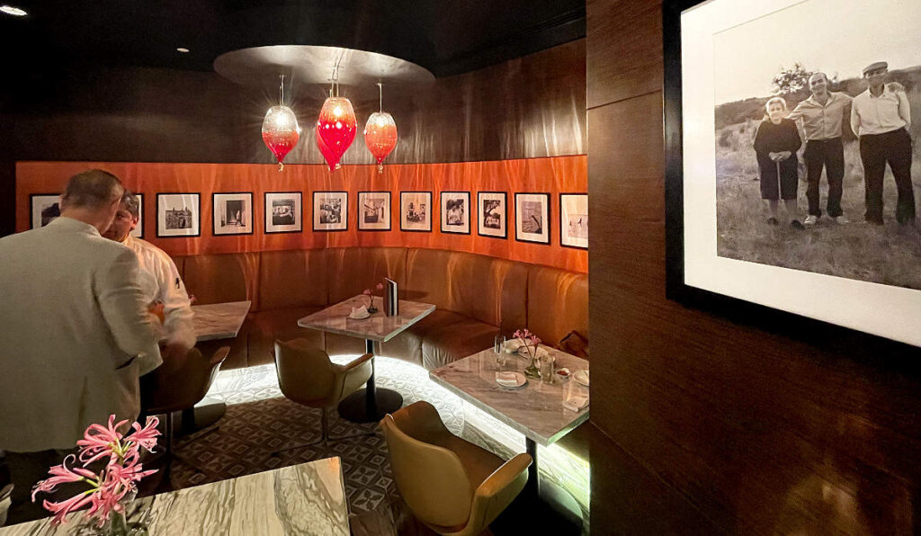 Foto panorâmica de um restaurante italiano luxuoso em Dubai, com salão elegante, mesas brancas impecavelmente montadas, iluminação suave, serviço refinado e ambiente exclusivo no coração financeiro da cidade. Atmosfera clássica, sofisticada e premium, ideal para turismo de luxo, jantares especiais e encontros de negócios nos Emirados Árabes Unidos.