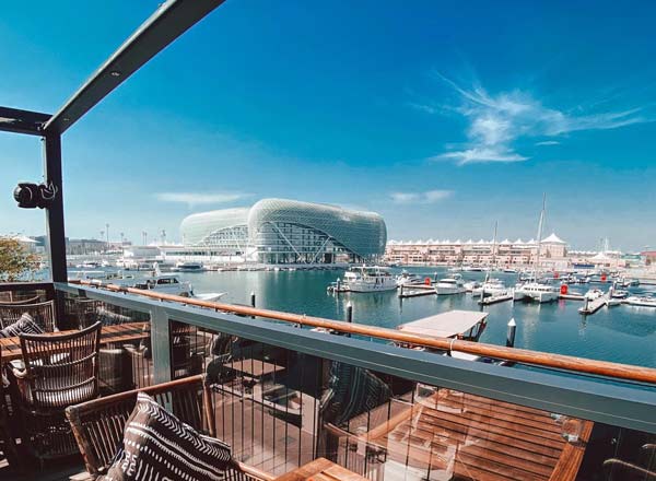 Foto panorâmica de um restaurante italiano luxuoso em Dubai, com salão elegante, mesas brancas impecavelmente montadas, iluminação suave, serviço refinado e ambiente exclusivo no coração financeiro da cidade. Atmosfera clássica, sofisticada e premium, ideal para turismo de luxo, jantares especiais e encontros de negócios nos Emirados Árabes Unidos.