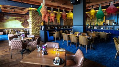 Foto panorâmica de um restaurante italiano luxuoso em Dubai, com salão elegante, mesas brancas impecavelmente montadas, iluminação suave, serviço refinado e ambiente exclusivo no coração financeiro da cidade. Atmosfera clássica, sofisticada e premium, ideal para turismo de luxo, jantares especiais e encontros de negócios nos Emirados Árabes Unidos.