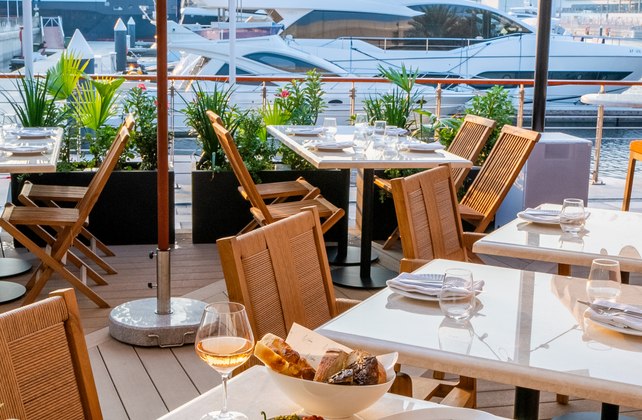 Foto panorâmica de um restaurante italiano luxuoso em Dubai, com salão elegante, mesas brancas impecavelmente montadas, iluminação suave, serviço refinado e ambiente exclusivo no coração financeiro da cidade. Atmosfera clássica, sofisticada e premium, ideal para turismo de luxo, jantares especiais e encontros de negócios nos Emirados Árabes Unidos.