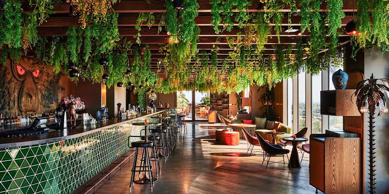 Foto panorâmica de um restaurante grego de luxo em Dubai, com decoração sofisticada em tons claros, frutos do mar frescos expostos, mesas elegantes e ambiente refinado no DIFC. Atmosfera exclusiva que transmite gastronomia mediterrânea premium, luxo e sofisticação internacional.