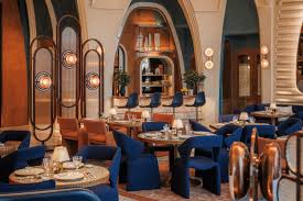 Foto panorâmica de um restaurante luxuoso em Dubai, com vista para o skyline moderno da cidade ao fundo. Ambiente sofisticado com mesas elegantes, decoração refinada e atmosfera exclusiva que transmite uma experiência gastronômica premium e turismo de luxo nos Emirados Árabes Unidos.
