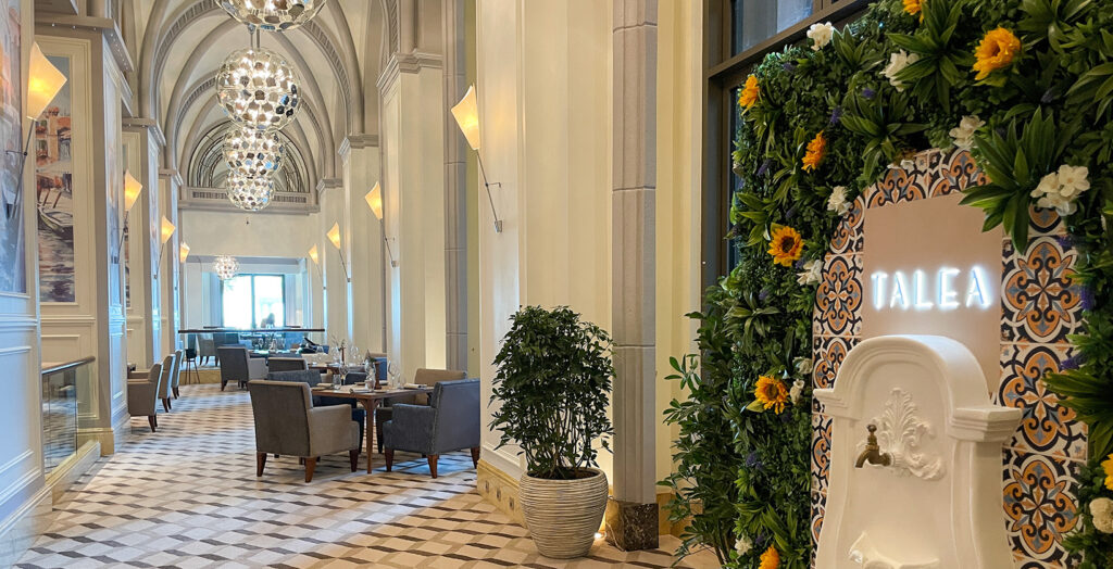 Foto panorâmica de um restaurante italiano luxuoso em Dubai, com salão elegante, mesas brancas impecavelmente montadas, iluminação suave, serviço refinado e ambiente exclusivo no coração financeiro da cidade. Atmosfera clássica, sofisticada e premium, ideal para turismo de luxo, jantares especiais e encontros de negócios nos Emirados Árabes Unidos.