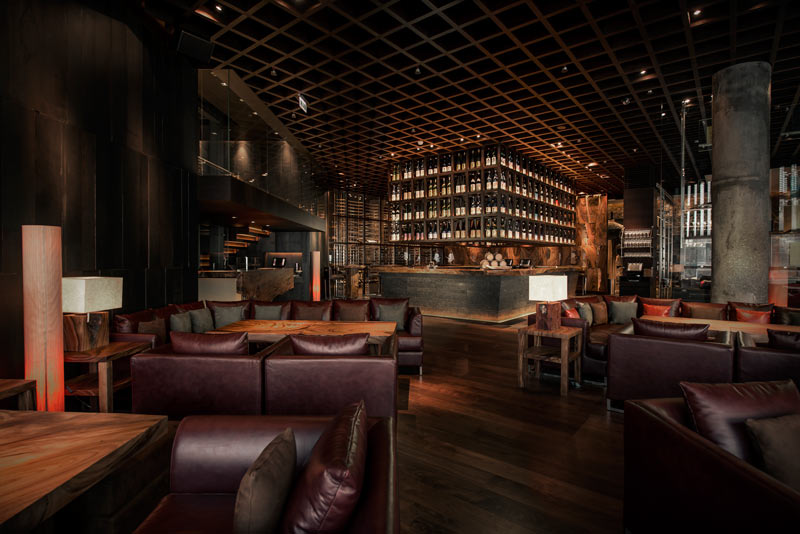 Foto panorâmica de um restaurante italiano luxuoso em Dubai, com salão elegante, mesas brancas impecavelmente montadas, iluminação suave, serviço refinado e ambiente exclusivo no coração financeiro da cidade. Atmosfera clássica, sofisticada e premium, ideal para turismo de luxo, jantares especiais e encontros de negócios nos Emirados Árabes Unidos.
